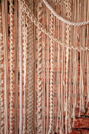 Macrame product on a background of a red brick wall in boho style.の写真素材