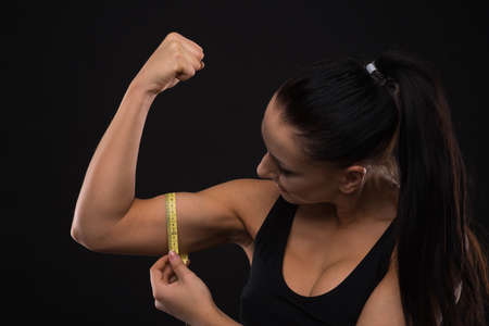 Young sportslooking nice lady with dark hair shows various performs exercises with equipment on the...