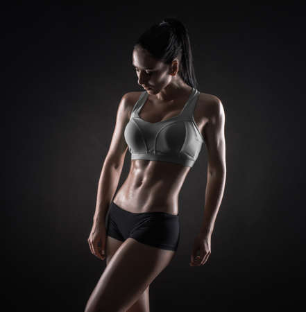 Young fitness woman showing her perfect sculpted muscular and tight bodyの写真素材
