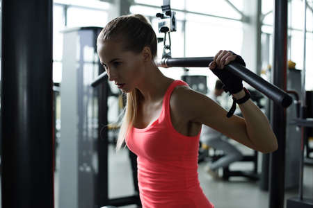 Athletic young woman resting during exercise in the gym