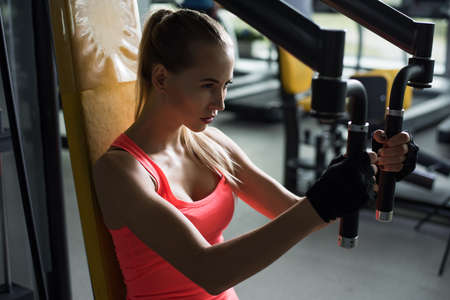 Athletic young woman resting during exercise in the gym