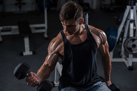 Handsome bodybuilder works out pushing up excercise in gym