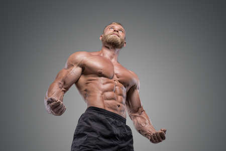 Handsome muscular man bodybuilder posing in the studio on a darck background