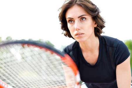 Beautiful young girl on an open tennis court playing tennisの写真素材