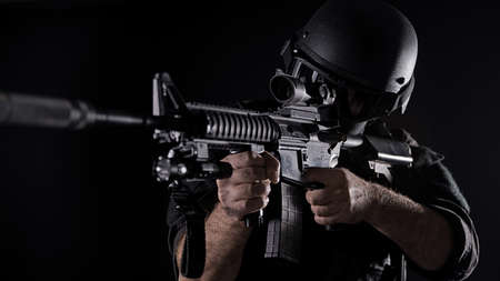 Spec ops police officer SWAT in black uniform on a studio background