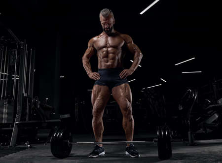 Brutal adult athlete posing in the gym. Fitness muscled man.の写真素材