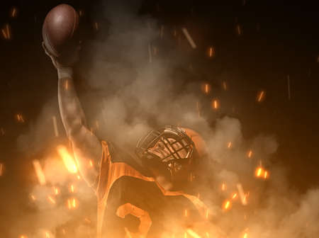 American football player on dark background in smoke and sparks in black and orange outfit.の写真素材