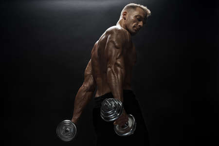Fitness model Man posing in the studio. Dark background.の写真素材