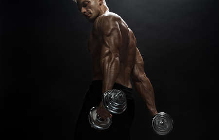 Fitness model Man posing in the studio. Dark background.の写真素材