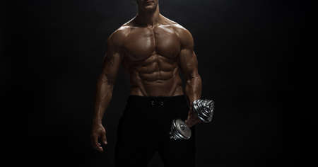Fitness model Man posing in the studio. Dark background.の写真素材