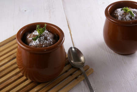 Chocolate dessert mug-cake with cocoa and peanut butter, decorated with powdered sugar and mint....