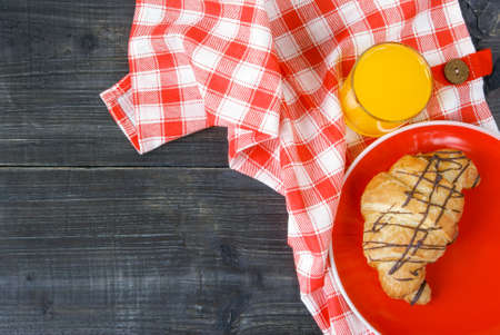 Breakfast or snack in the countryside. At the rustic wooden table - red tablecloth in a cage, a...