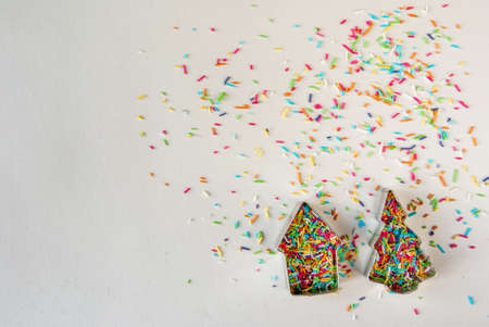 Christmas mood. Cookie cutters for Christmas cookies and colorful sprinkling of cookies on a white background.の写真素材