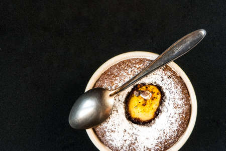 One chocolate dessert with a pear on a black stone table, top view, copy spaceの写真素材