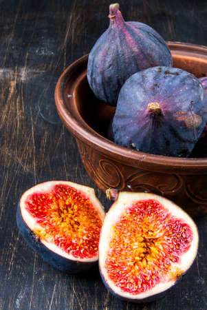 Ripe raw figs on a black wooden tableの写真素材