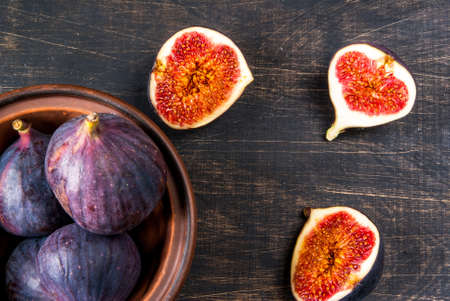 Ripe raw figs on a black wooden table