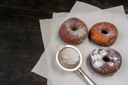 Fresh homemade donuts sprinkled with powdered sugar, top view, copy spaceの写真素材
