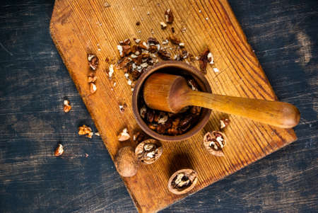 Walnuts in a mortar for grinding on a wooden board, Rustic style, top view