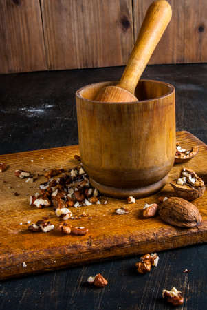 Walnuts in a mortar for grinding on a wooden board, Rustic styleの写真素材