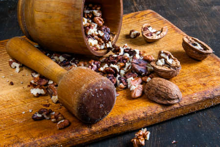 Walnuts in a mortar for grinding on a wooden board, Rustic styleの写真素材