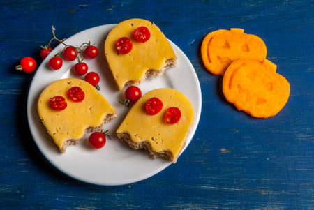 Funny food for a child for Halloween: the sandwiches in the shape of ghosts and slices of fresh...