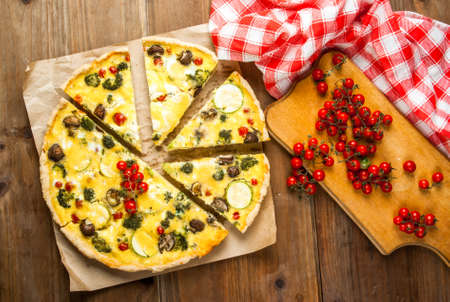 Freshly baked homemade pie quiche lorraine on a wooden tableの写真素材