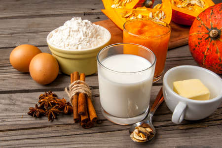 Selection of ingredients for making a traditional pumpkin pie for Thanksgiving or Halloween. At the rustic wooden table, copy spaceの写真素材
