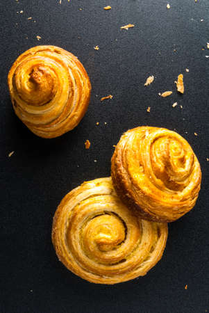 Freshly baked cinnamon rolls on a black backgroundの写真素材