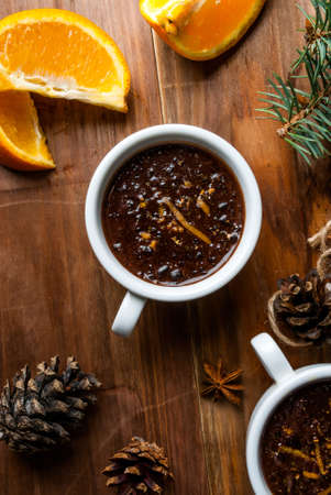 Hot chocolate with spices, orange and orange zest. Against the background of Christmas tree...