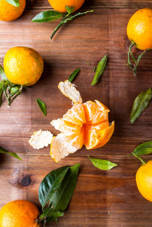 Tangerines with leaves on the wooden table, top viewの写真素材