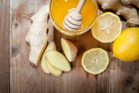 Selection products for making ginger tea: ginger, honey, lemon. On wooden table, top view, copy spaceの写真素材