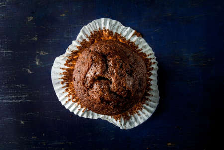 Freshly baked chocolate muffins with lemon kurd inside, on a dark blue wooden table. Copy spaceの写真素材