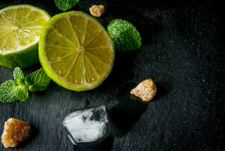 Ingredients for mojito or cocktail with tequila - lime, fresh mint, ice, brown sugar, close viewの写真素材