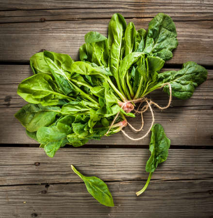 Bunch of fresh raw spinach on a rustic wooden table, top viewの写真素材