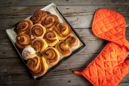 Freshly baked homemade cinnamon rolls, on a wooden table, with tack. Top viewの写真素材