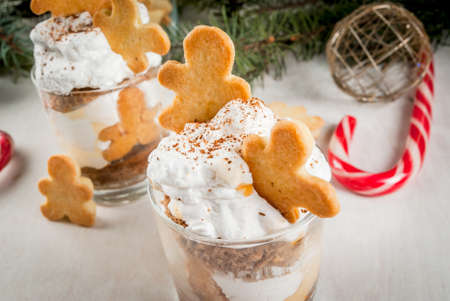 Christmas dessert, funny food for children or party. Ginger Trifle with gingerbread in form of men, diving in the drifts of whipped cream.の写真素材