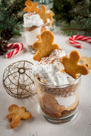 Christmas dessert, funny food for children or party. Ginger Trifle with gingerbread in form of men, diving in the drifts of whipped cream.の写真素材