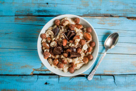 Nourishing and delicious breakfast, oatmeal with hazelnuts, dark chocolate and a chocolate corn balls. Copy spaceの写真素材