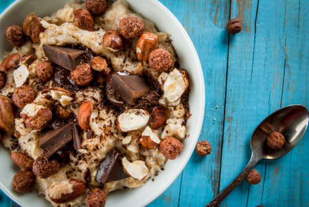 Nourishing and delicious breakfast, oatmeal with hazelnuts, dark chocolate and a chocolate corn balls. Copy spaceの写真素材