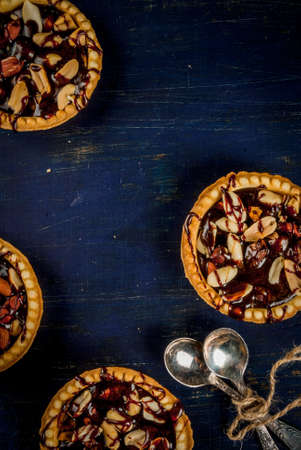 Mini tarts with nuts and caramel on a rustic background, top view, copy spaceの写真素材