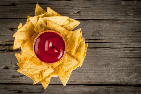 Snack for party, chips, nachos with sauces: tomato (ketchup), cheese and mayonnaise (tartar), copy space, top viewの写真素材