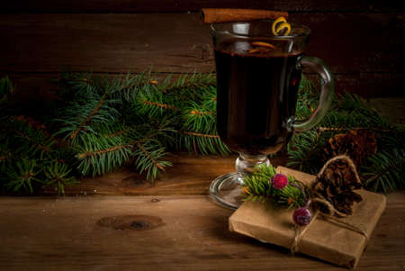 Traditional Christmas drink mulled wine, next to the Christmas tree branches, presents and decorations, copy spaceの写真素材