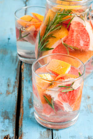 Refreshing summer detox cocktail of grapefruit and rosemary, on wooden rustic table, copy space, close viewの写真素材