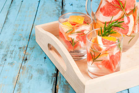 Refreshing summer detox cocktail of grapefruit and rosemary, on wooden rustic table, copy spaceの写真素材