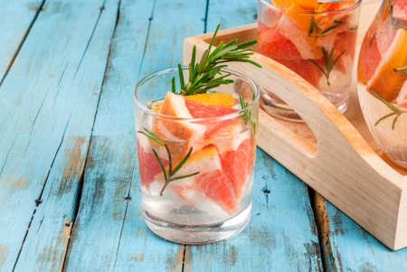 Refreshing summer detox cocktail of grapefruit and rosemary, on wooden rustic table, copy spaceの写真素材