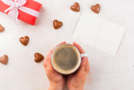 Concept for the celebration of Valentine's flavored coffee, candy heart shaped gift in red paper...