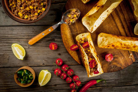 Traditional Mexican dish tacos with ingredients: meat, tomatoes, limes, fresh and pickled hot peppersの写真素材