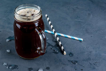 Iced coffee in a Mason Jar with straws and ice om the background. copy spaceの写真素材
