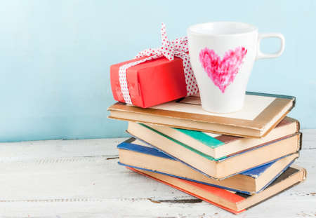 Idea to design a romantic breakfast on Valentine's Day: a gift with a ribbon and a mug of coffee with a heart drawn on it with lipstickの写真素材