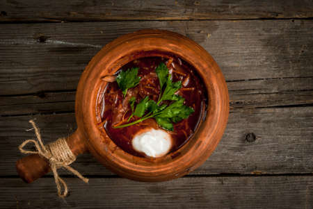 Traditional Ukrainian and Russian meal (soup) - borscht in authentic national dishes. At the rustic wooden table. Top view, copy spaceの写真素材